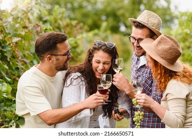 Happy friends having fun drinking wine at winery vineyard - Friendship concept with young people enjoying harvest time together - Shutterstock ID 2166650571