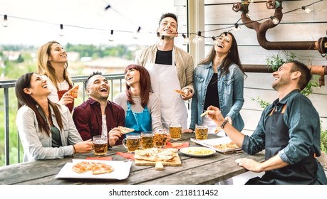Happy friends having fun eating pizza on balcony at house dinner party - Young people drinking beer at fancy alternative restaurant together - Dining life style concept on bright warm filter