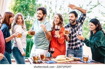 Happy Friends Having Fun Eating At House Balcony Dinner Party - Young People Drinking Beer And Wine At Fancy Alternative Roof Top Venue Together - Dinning Life Style Concept On Bright Contrast Filter