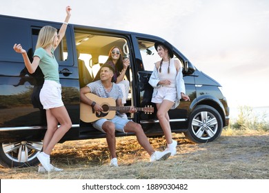 Happy friends having fun near car outdoors. Summer trip - Powered by Shutterstock