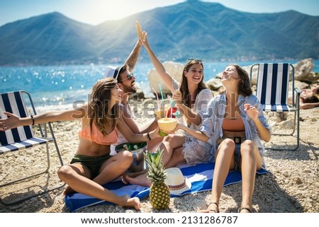 Happy friends having fun with tropical cocktails on beach party. Travel and summer vacation concept.