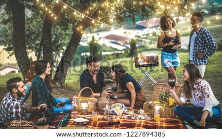 Happy friends having fun at vineyard after sunset - Young people millennial camping at open air picnic under bulb lights - Youth friendship concept with guys and girls drinking wine at barbecue party