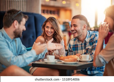 Happy friends having a great time in cafe. Friends sitting in a coffee shop, drinking coffee and having fun together. - Powered by Shutterstock