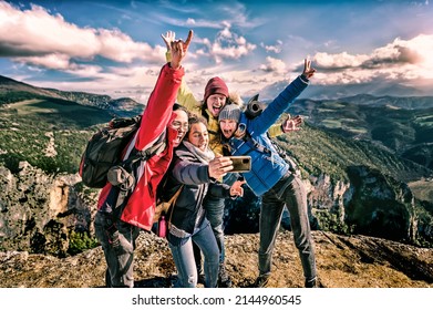 Happy friends hikers with backpacks taking selfie portrait on the top of mountain - Smiling happy climbing tourists enjoying summer holidays at high altitude - Freedom, success sport concept