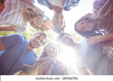 Happy Friends Huddling In Circle In The Park On A Sunny Day