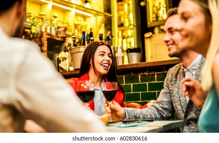 Happy Friends Laughing And Toasting Wine In Trendy Cocktail Bar Restaurant - Young People Having Fun Drinking Appetizer - Focus On Left Woman Face - Warm Contrast Filter Photo Taken With Flash