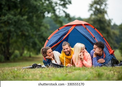 Happy friends lying in their tent in the countryside - Shutterstock ID 330555170