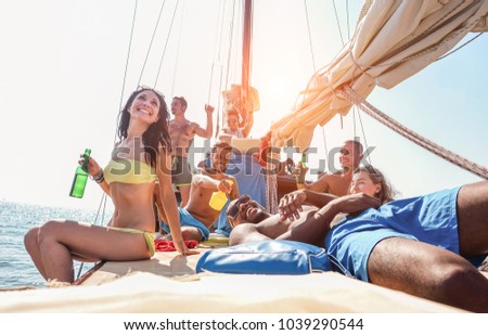 Happy friends making boat party with dj playing music at sunset - Young people having fun drinking beers and laughing together in sail sea excursion - Focus on bottom guys - Summer and youth concept