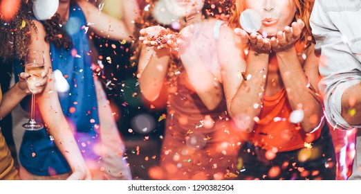 Happy Friends Making Carnival Party Throwing Confetti - Young People Celebrating On Weekend Night - Entertainment, Fun, Nightlife And Fest Concept - Focus On Center Girl Hands