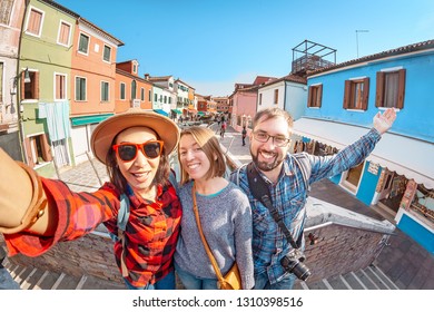 Happy friends making selfie photo in Burano island in Venice. Travel and vacation in Italy concept