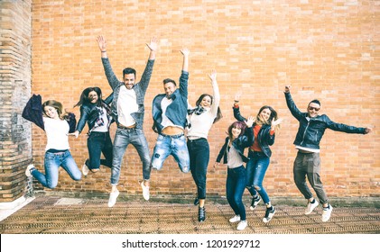 Happy friends millennials jumping and cheering against brick wall in the city - Friendship lifestyle and team concept with young people millenial having fun together - Teal and orange vintage filter