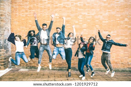 Happy friends millennials jumping and cheering against brick wall in the city - Friendship lifestyle and team concept with young people millenial having fun together - Teal and orange vintage filter