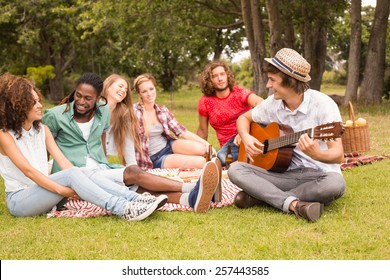 Happy Friends In The Park Having Picnic On A Sunny Day