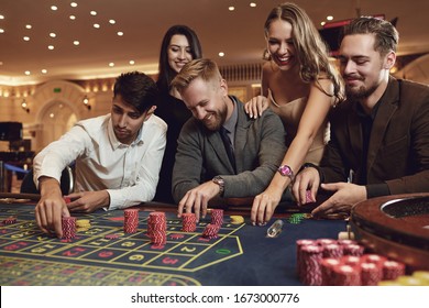 Happy friends play roulette in a casino. - Powered by Shutterstock