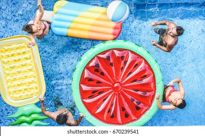 Happy friends playing with ball inside swimming pool - Young people having fun on summer holidays vacation - Travel,holidays,youth,friendship and tropical concept - Seasonal color tones filter - Powered by Shutterstock