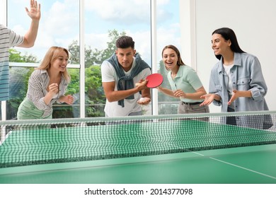 Happy friends playing ping pong together indoors - Powered by Shutterstock