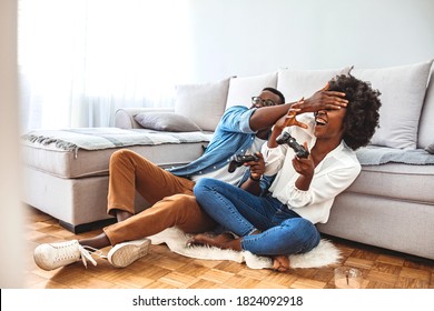 Happy Friends Playing Video Games With Virtual Reality Glasses - Young People Having Fun With New Technology Console Online. Young African American Couple Playing On Game Console With Joysticks