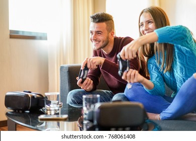 Happy friends playing video games - Young people having fun with new technology console online - Happiness and gaming concept - Soft focus on man face - Warm filter - Powered by Shutterstock