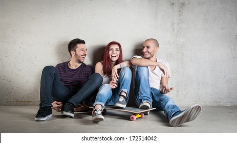 Happy friends portrait with skateboard against concrete wall.  - Powered by Shutterstock