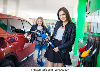 Happy Friends Refuel Car In Gas Station. Holiday Trip Of Friends