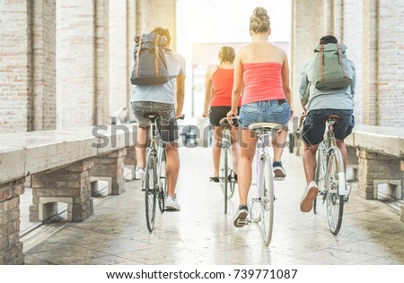 Happy friends riding city bikes in old town center - Young students having fun together going around with bicycles - Youth, friendship and lifestyle concept - Focus on right woman body 