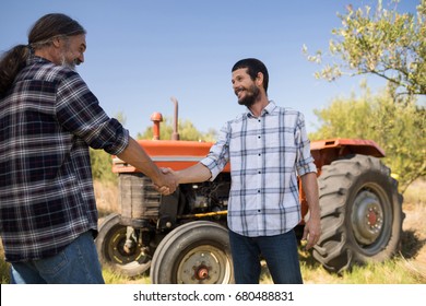 Happy friends shaking hands in farm on a sunny day - Powered by Shutterstock