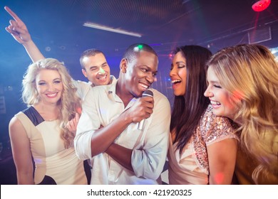 Happy Friends Singing At The Karaoke In Night Club