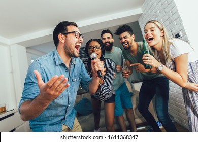 Glückliche Freunde singen zu Hause zusammen. Karaoke-Party-Konzept