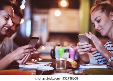 Happy Friends Take A Food Picture For Instagram In Cafe