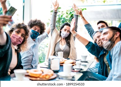 Happy friends taking selfie at coffee bar wearing face mask - New normal lifestyle and gathering concept with young people having fun together at restaurant cafe after reopening - Bright azure filter - Shutterstock ID 1899254533