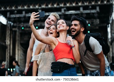 Happy friends taking selfie at music festival - Powered by Shutterstock