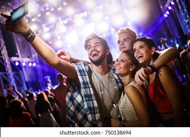 Happy Friends Taking Selfie At Music Festival