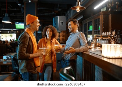 Happy friends talking while drinking beer at bar counter desk - Powered by Shutterstock