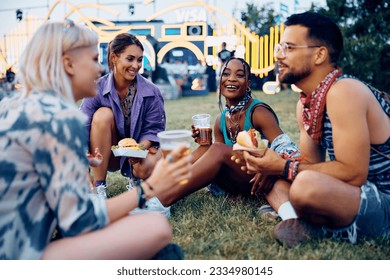 Happy friends talking while drinking beer and eating hamburgers during summer music festival. - Powered by Shutterstock