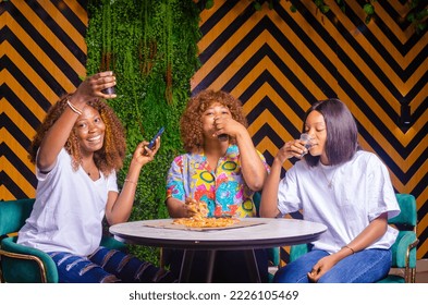 happy friends or teen girls eating pizza at home - Powered by Shutterstock