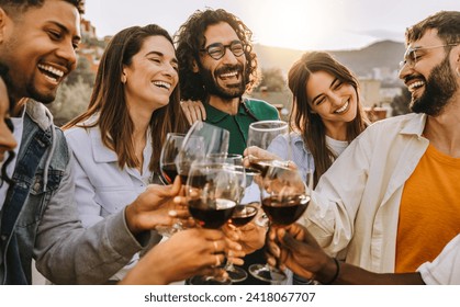 Happy friends toasting red wine glasses outside - Group of young people having bbq dinner party in backyard house - Winery and bbq dining concept with guys and girls cheering alcohol together - Powered by Shutterstock