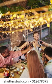 Happy Friends Toasting With Red Wine At Thanksgiving Party