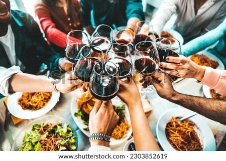Happy friends toasting red wine glasses at diner party - Group of people having lunch break at bar restaurant - Life style concept with guys and girls hanging out together - Food and beverage 
