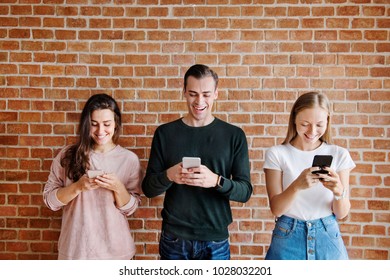 Happy friends using smartphones social media concept