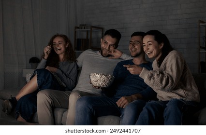 Happy friends watching comedy film and laughing, relaxing at home together - Powered by Shutterstock