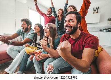 Happy friends watching soccer world cup on television at home - Powered by Shutterstock