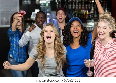 Happy Friends Watching Sport In A Bar