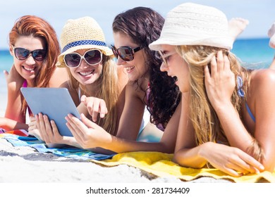 Happy Friends Wearing Sun Glasses And Using Tablet At The Beach