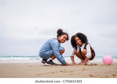 Happy friendship. Happy vacation holiday. Happy two African American kids are building a sandcastle on the tropical beach and have fun together in summer. Relaxation in vacation in the summer concept. - Powered by Shutterstock