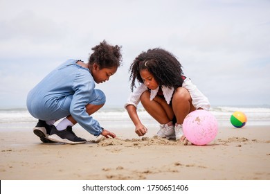 Happy friendship. Happy vacation holiday. Happy two African American kids are building a sandcastle on the tropical beach and have fun together in summer. Relaxation in vacation in the summer concept. - Powered by Shutterstock