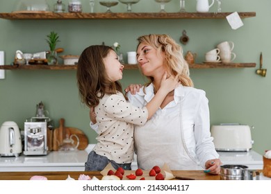 Happy Fun Chef Cook Baker Mom Woman Wear White Shirt Work With Child Baby Girl Helper Hugging Mum At Kitchen Table Home Cooking Food Process Concept Mommy Little Kid Daughter Prepare Fruit Sweet Cake.