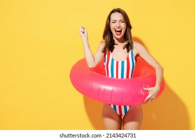 Happy Fun Young Sexy Woman Slim Body Wear Striped Red Blue One-piece Swimsuit Hold Pink Inflatable Ring Isolated On Vivid Yellow Color Wall Background Studio Summer Hotel Pool Sea Rest Sun Tan Concept