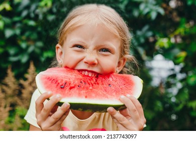 Happy funny child girl eats watermelon outdoor. Summertime - Powered by Shutterstock