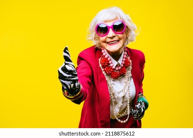 Happy and funny cool old lady with fashionable clothes portrait on colored background - Youthful grandmother with extravagant style, concepts about lifestyle, seniority and elderly people - Shutterstock ID 2118875612