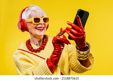 Happy and funny cool old lady with fashionable clothes portrait on colored background - Youthful grandmother with extravagant style, concepts about lifestyle, seniority and elderly people - Shutterstock ID 2118875615
